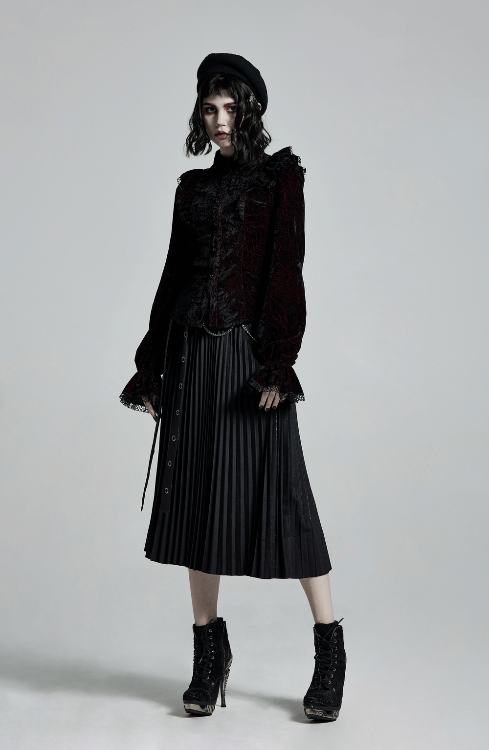 Gothic velvet blouse with lace-up back, ruffled details, paired with a pleated skirt for a dark romantic look.