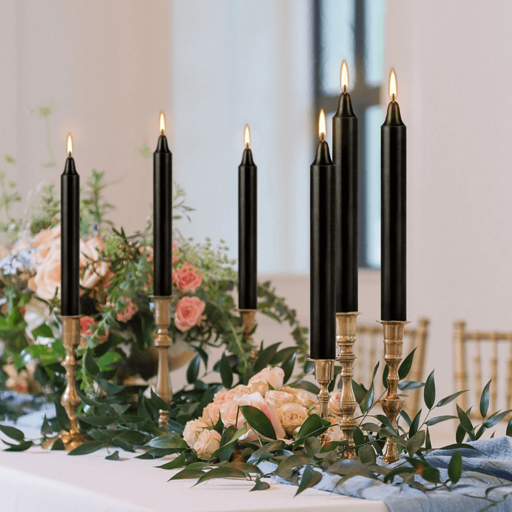 Elegant black drip-free candles on gold candlesticks, perfect for weddings and special events, adding a sophisticated glow.