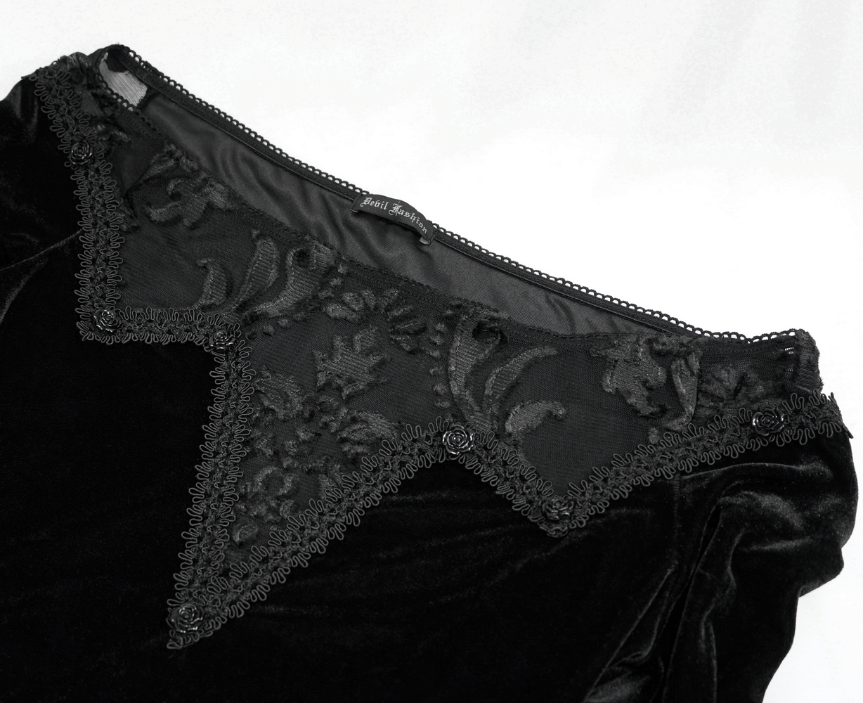 Close-up of black velvet dress with transparent lace insert, showcasing gothic style and elegant detailing.