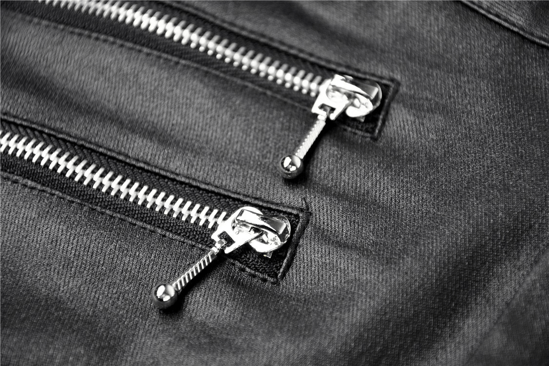 Close-up of edgy silver zippers on dark skinny pants, showcasing punk style and fashion details.