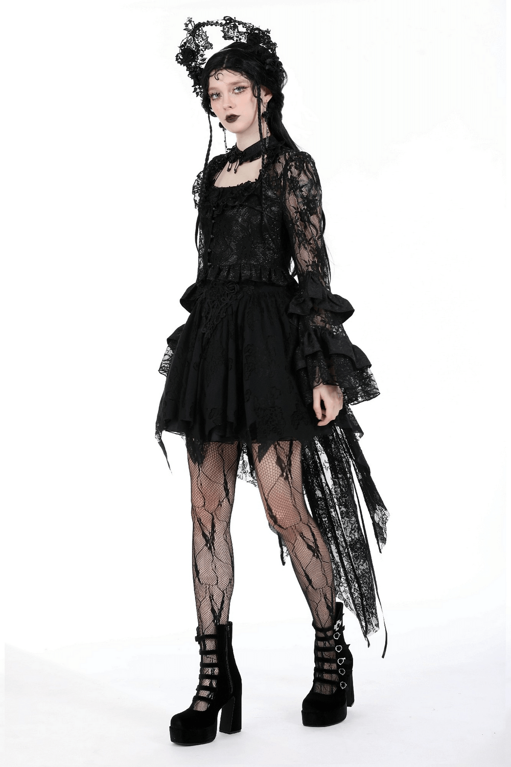 Gothic inspired model in sheer black lace top with bell sleeves and a layered skirt, perfect for evening wear.