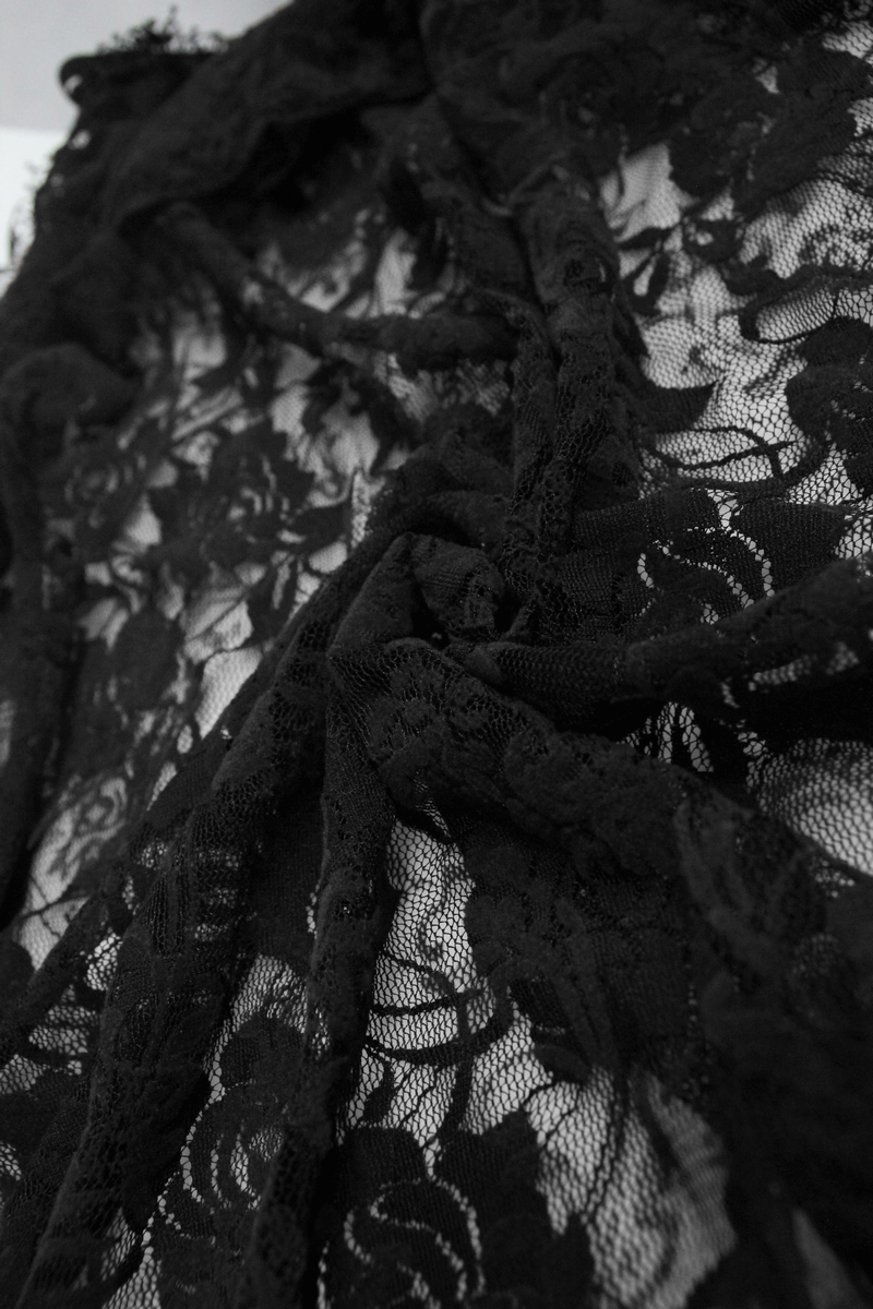 Close-up of elegant black lace fabric showcasing intricate floral patterns for a gothic-style night dress.
