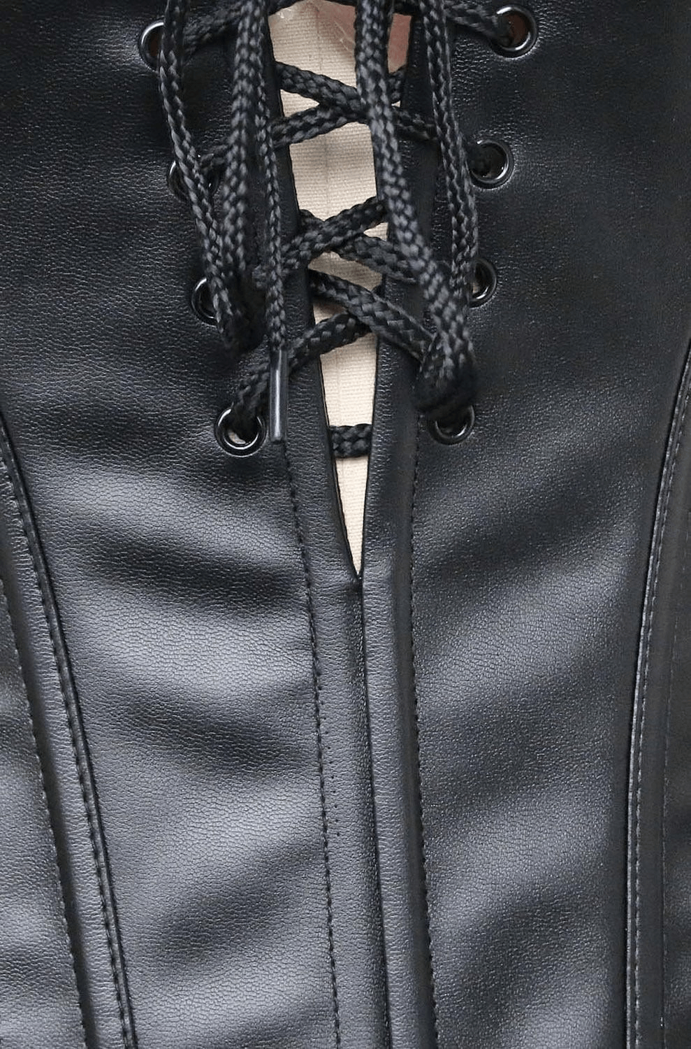 Close-up of black gothic lace-up corset with detailed stitching and eyelets for an edgy, sexy look.