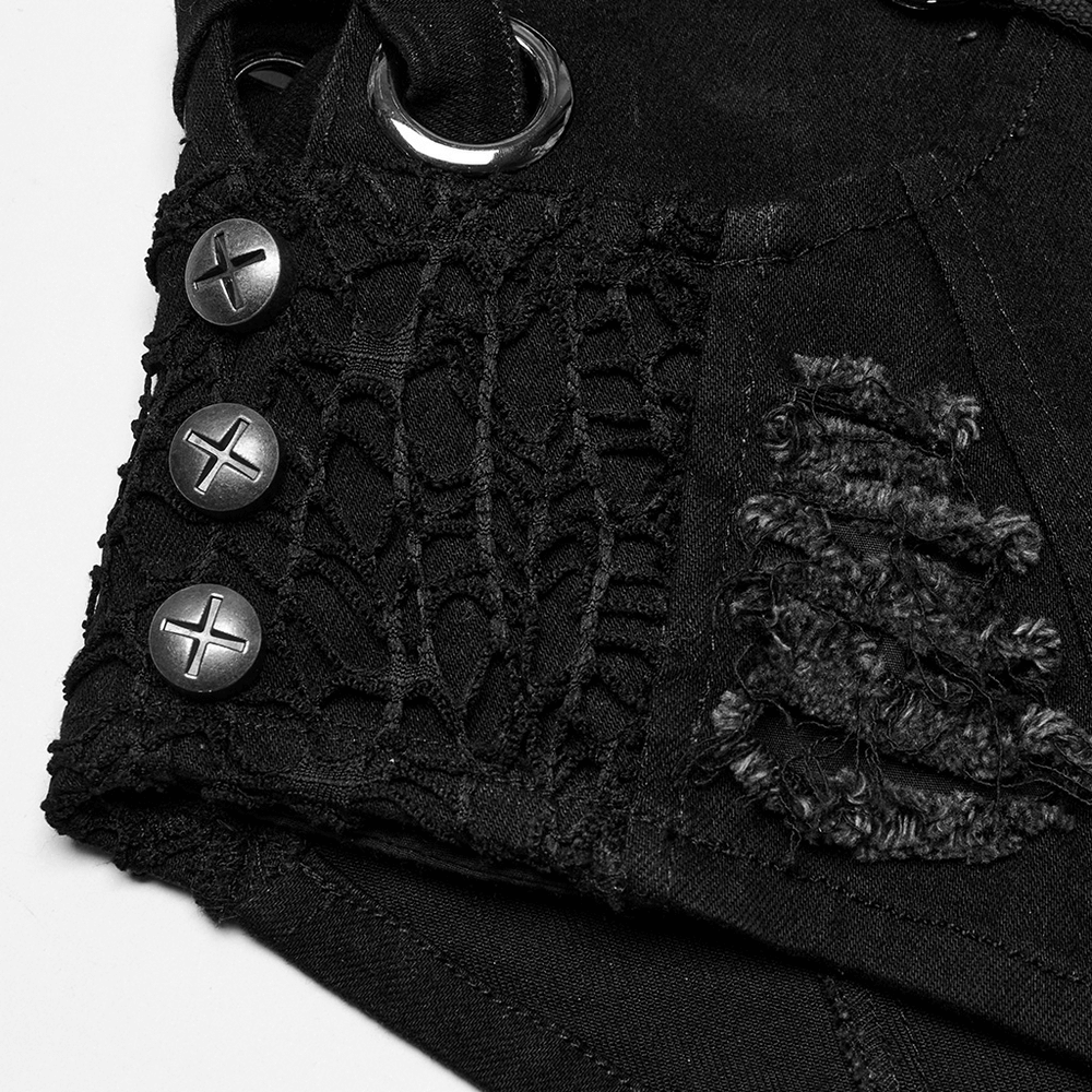 Close-up of punk-inspired black denim shorts with metal buttons and distressed lace detailing.