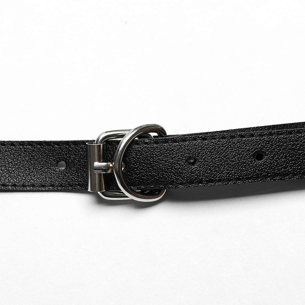 Adjustable buckle on faux leather harness strap with metal ring and spike studs for a punk-inspired edgy look.