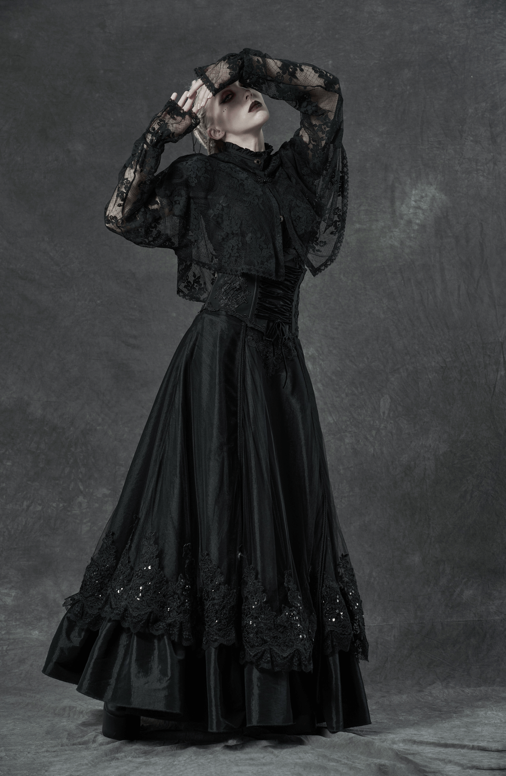 Gothic fashion model in black lace blouse and long skirt, showcasing dark elegance and vintage style.