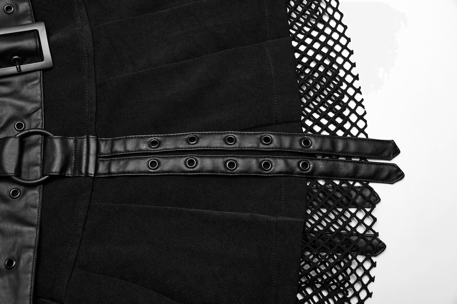 Close-up of a black pleated mini skirt with a faux leather belt and mesh detailing, perfect for an edgy punk style.