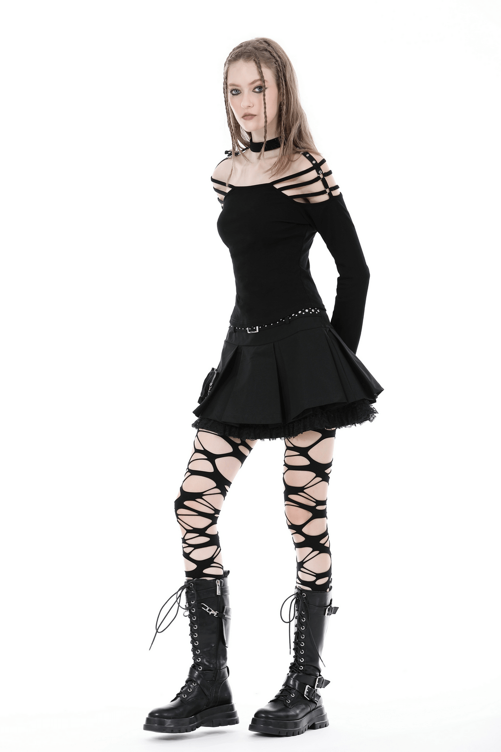 Model in a sexy gothic off-shoulder top, black mini skirt, and lace-up leggings, showcasing edgy dark fashion style.