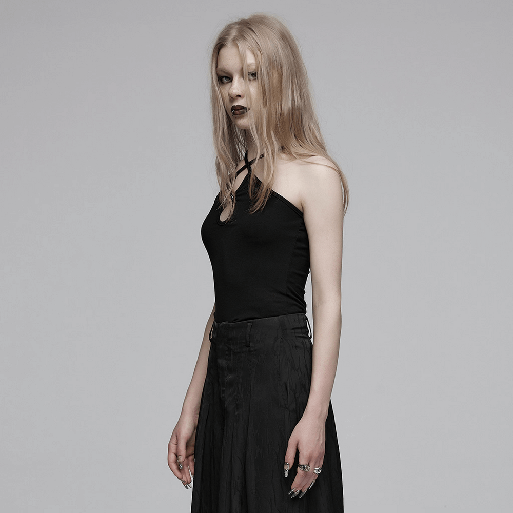 Edgy black halter camisole with unique buckle, styled for a chic rockstar look and paired with a flowing skirt.
