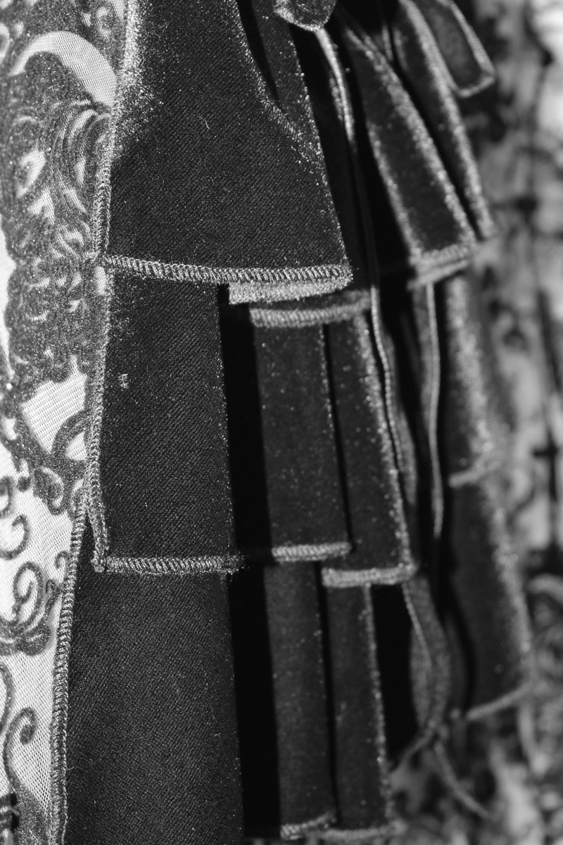 Close-up of black lace details on a gothic dress, featuring luxurious ruffles and intricate patterns.