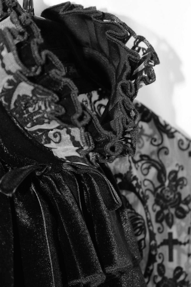 Close-up of a black lace gothic dress with intricate detailing and ruffles, showcasing elegant fashion design.