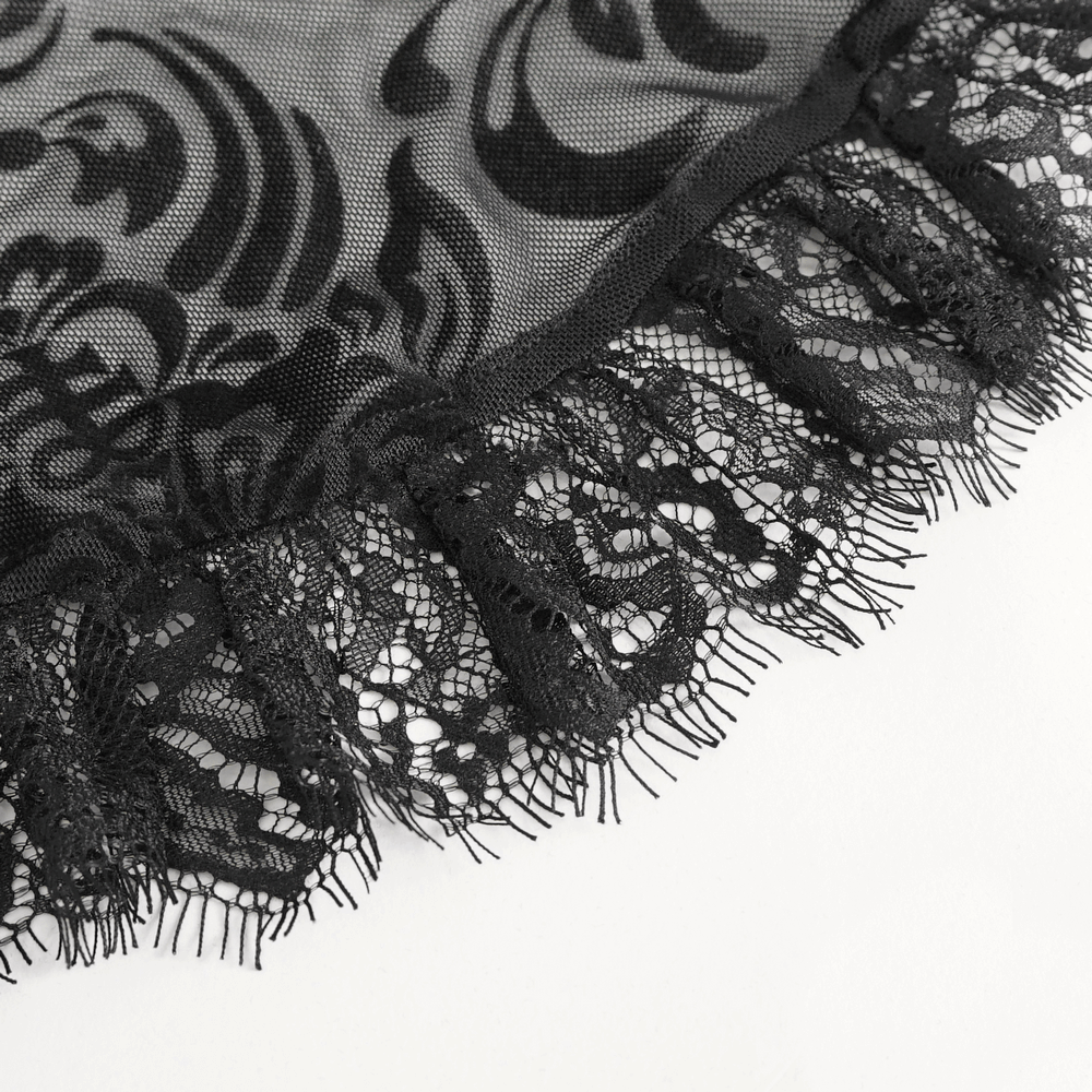 Close-up of black lace fabric with intricate patterns and fringe detail, showcasing elegance and sophistication.