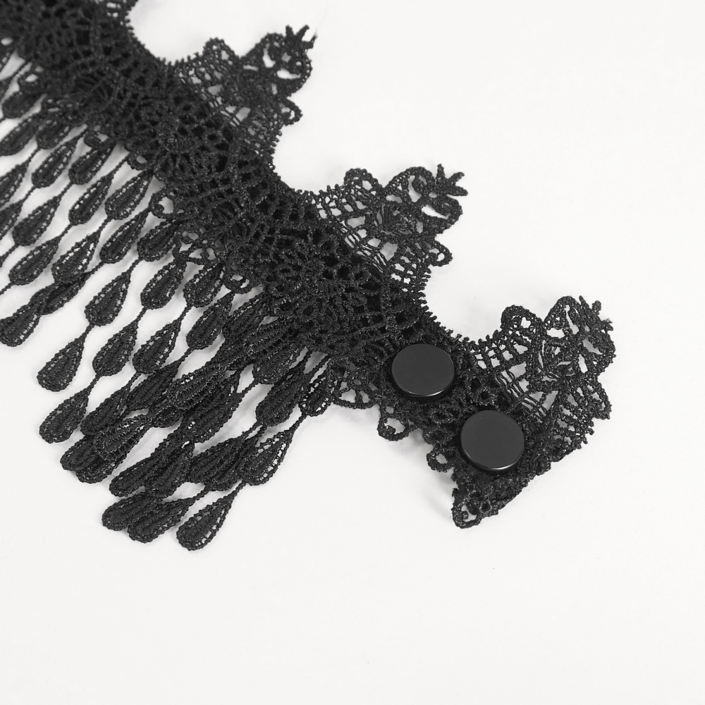 Close-up of intricate black lace detailing with fringe accents and buttons, perfect for a chic blouse.