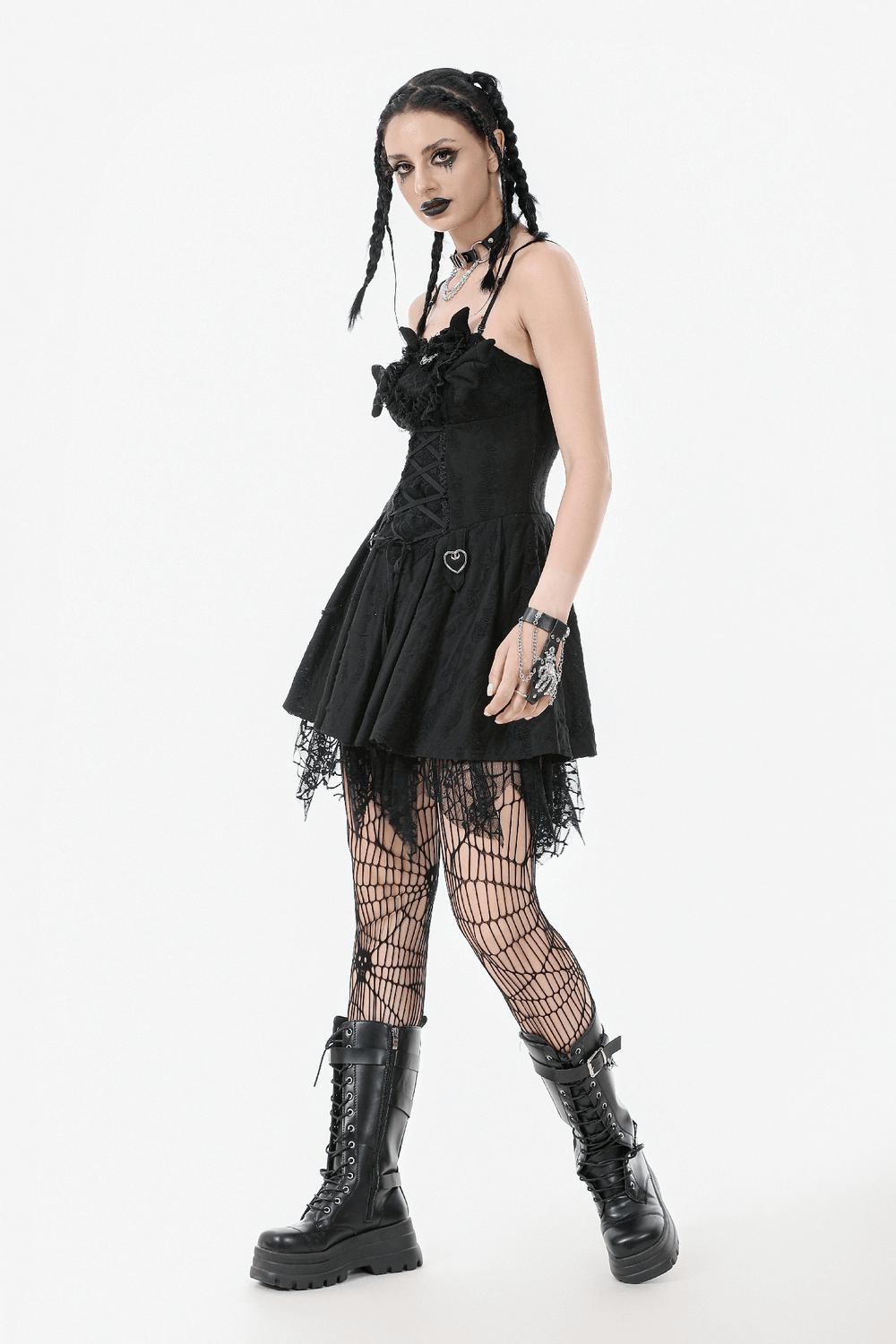 Woman in a black lace corset dress with heart clips, paired with fishnet stockings and chunky boots.