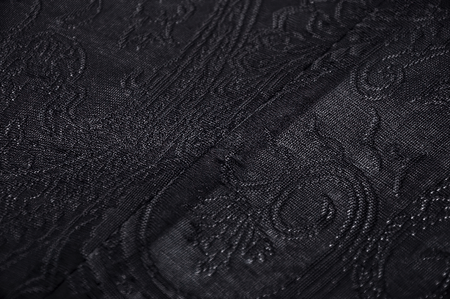 Close-up of elegant black lace fabric with intricate patterns, perfect for gothic fashion and stylish outfits.