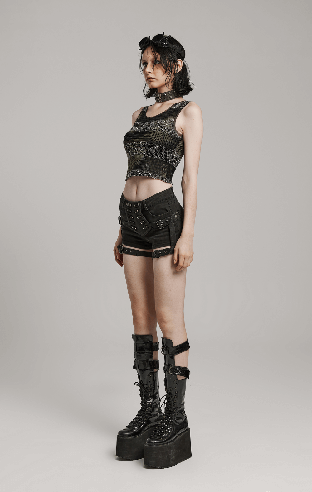Edgy look featuring a model in lace-up detail denim hot shorts, black crop top, and chunky platform boots.