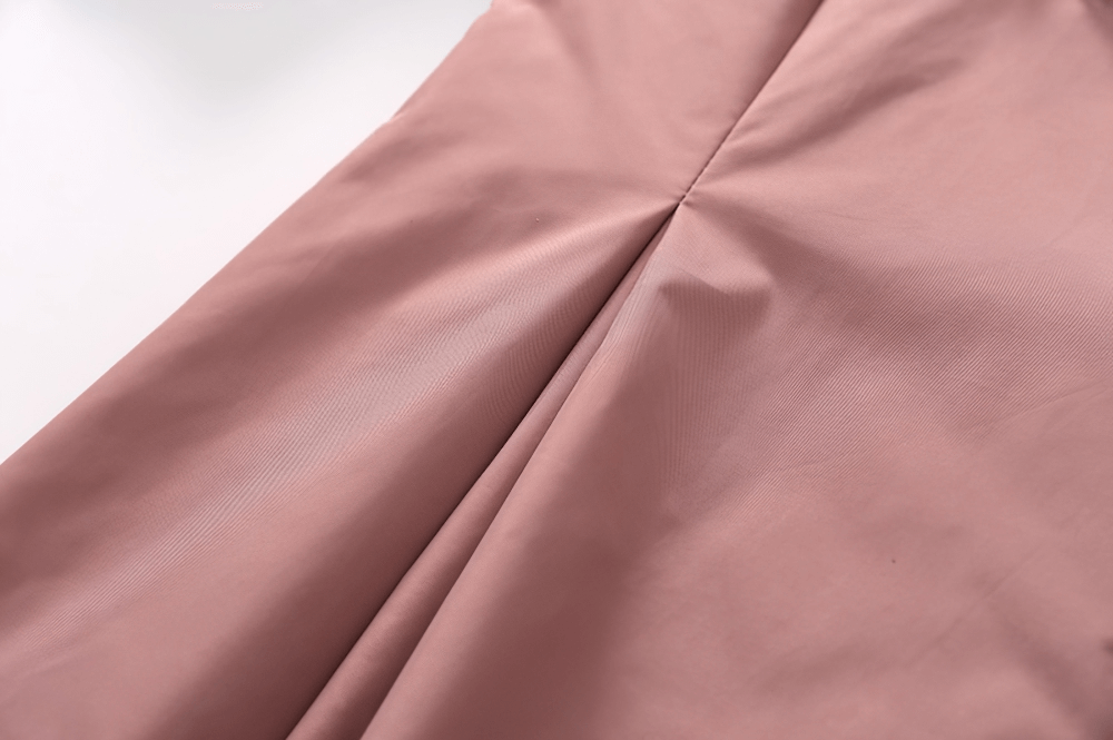 Close-up of soft pink fabric showcasing elegant draping and texture, perfect for a gothic-inspired dress.