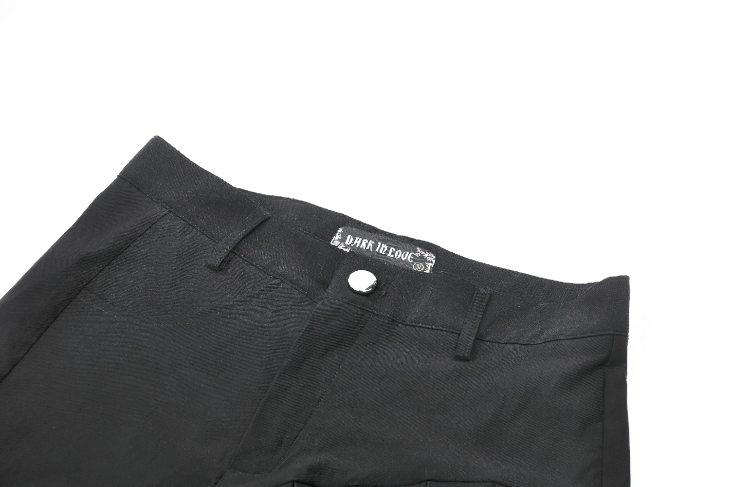 Close-up of sexy pleated black shorts with O-ring strap and studded back pocket detail, perfect for punk fashion.