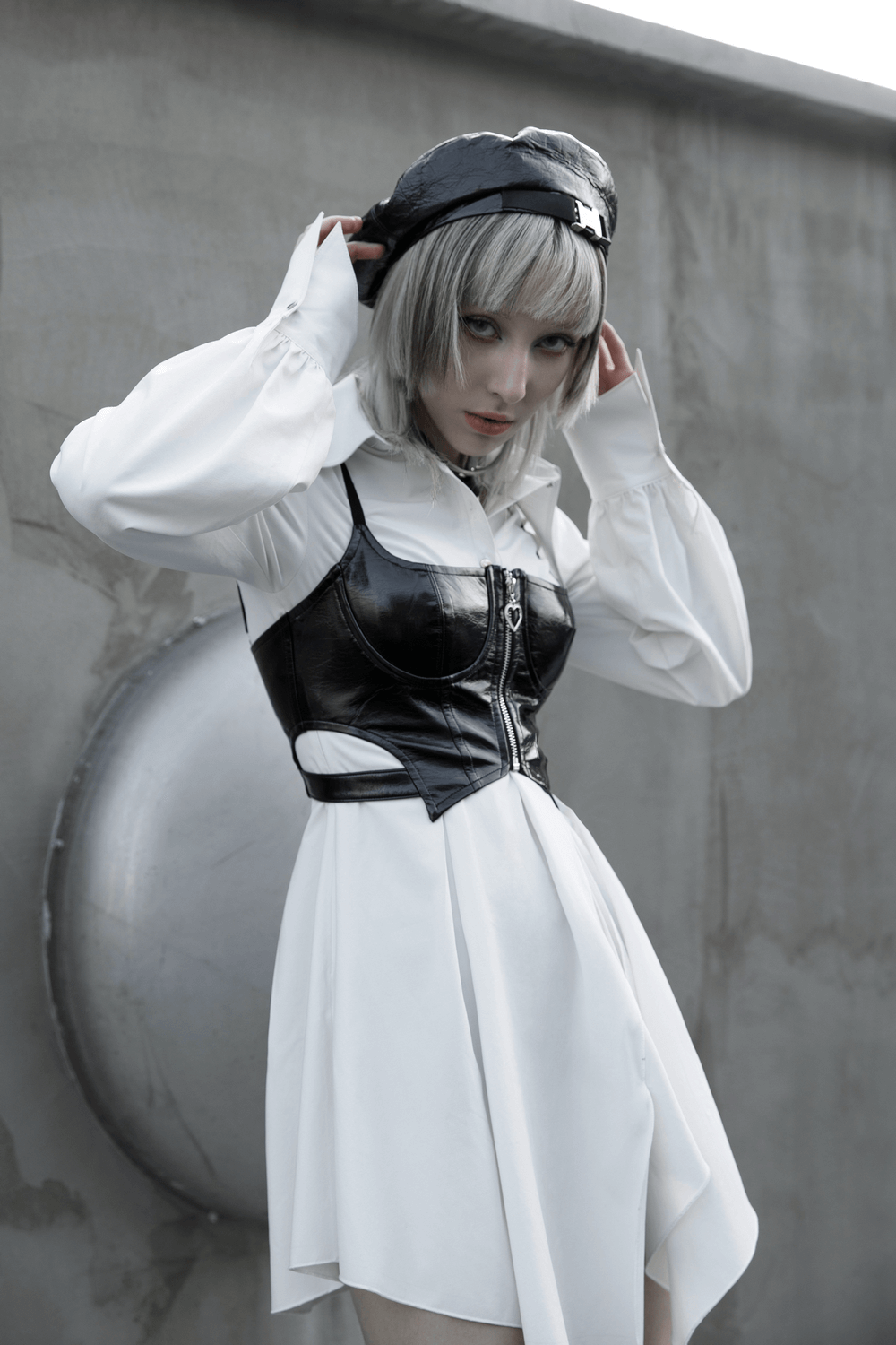 Model wearing a black PU leather zipper crop camisole with a white shirt, showcasing punk rave style and edgy fashion.