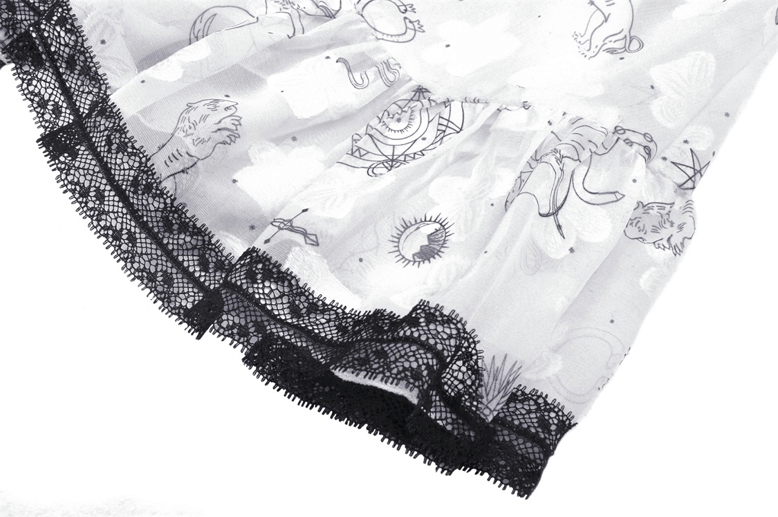 Close-up of punk strap dress showcasing edgy black lace trim and playful animal print design on white fabric.