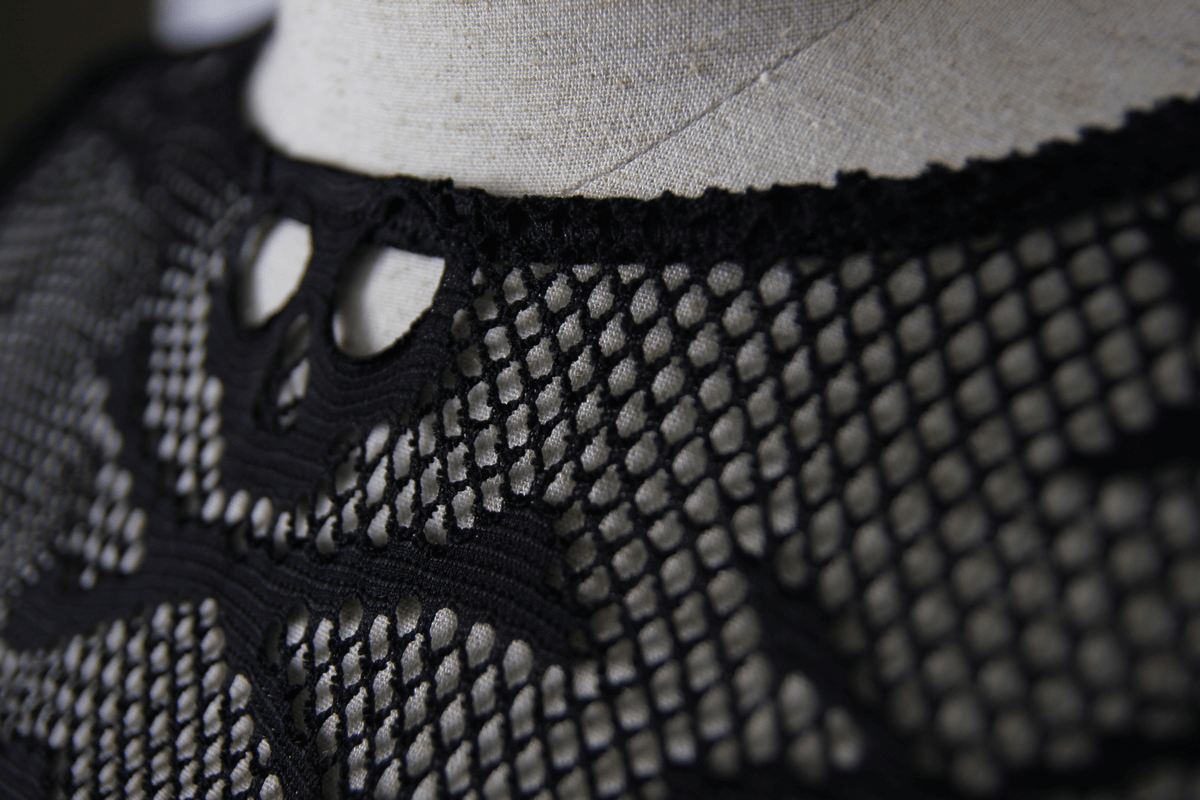 Close-up of a women's black mesh top featuring a skull design, perfect for gothic fashion enthusiasts.