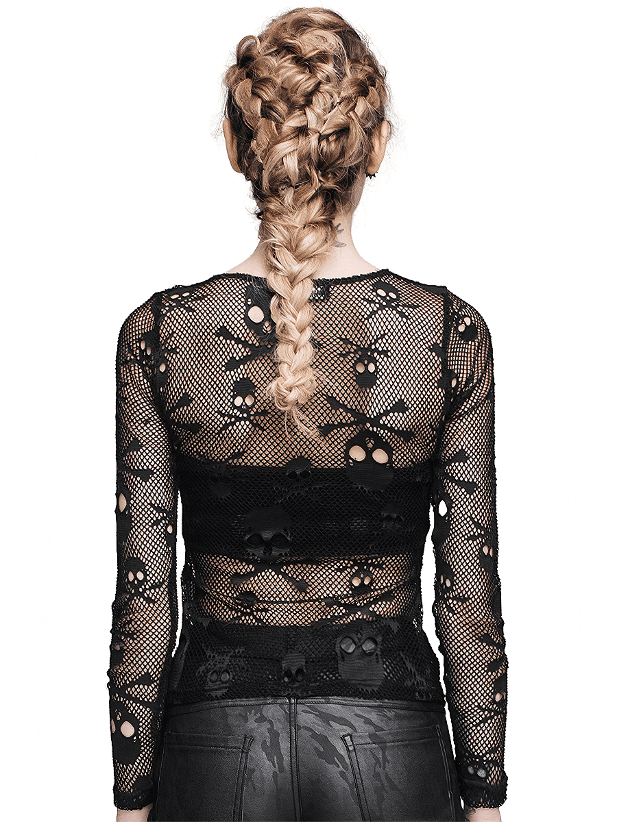Back view of a stylish woman in a black mesh skull top, showcasing gothic fashion with intricate skull designs.