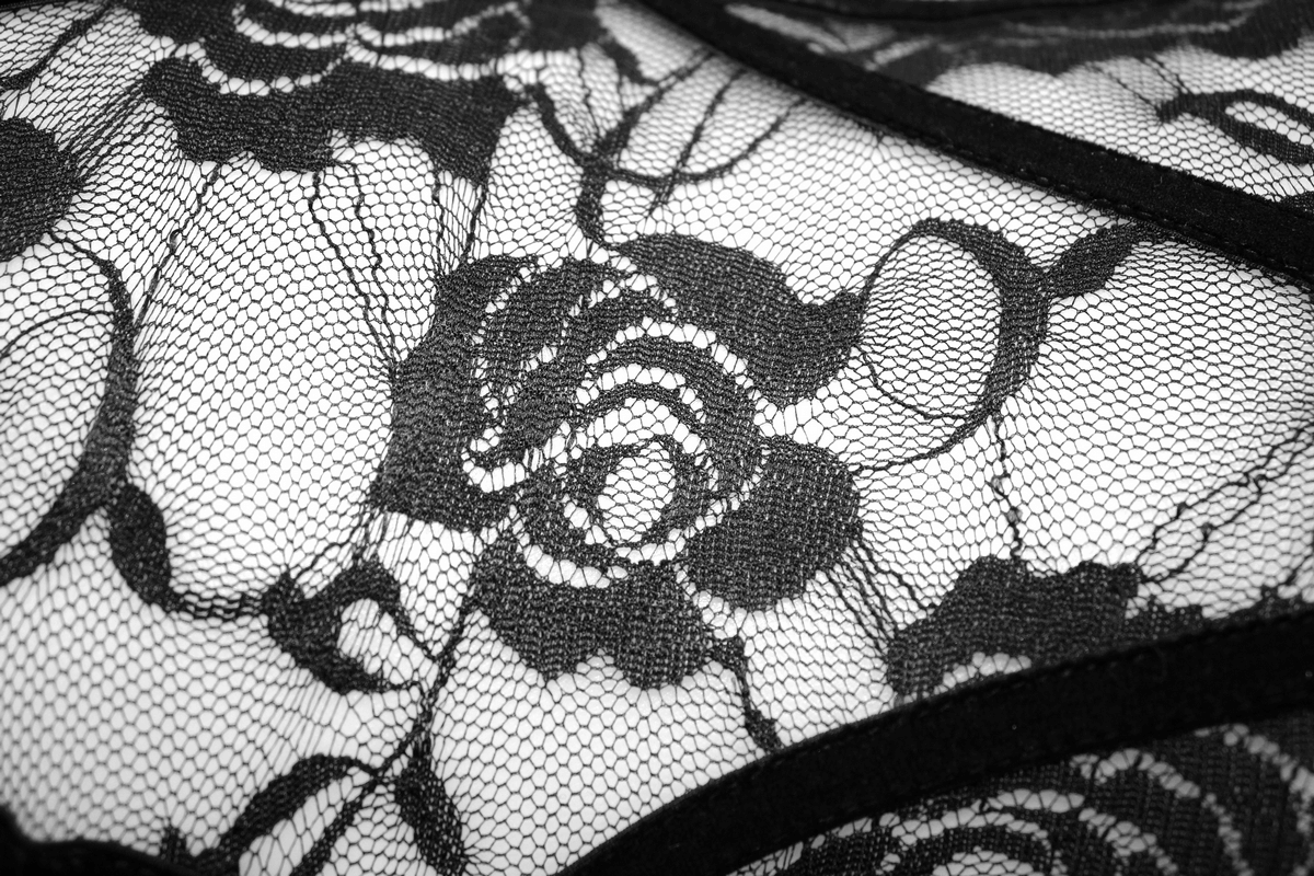 Close-up of intricate black lace fabric with floral pattern, perfect for gothic-themed outfits or lingerie.