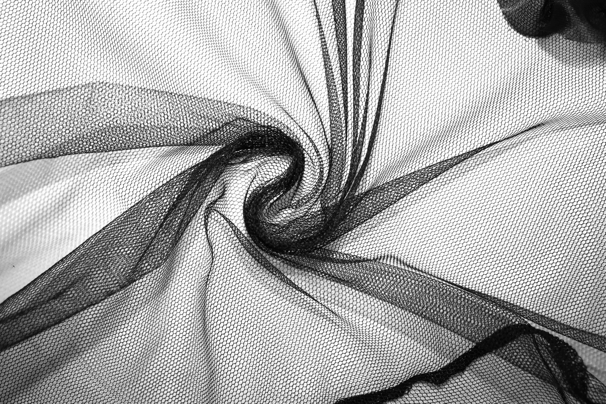 Close-up of black transparent lace fabric swirling, perfect for gothic and sexy bodysuits.