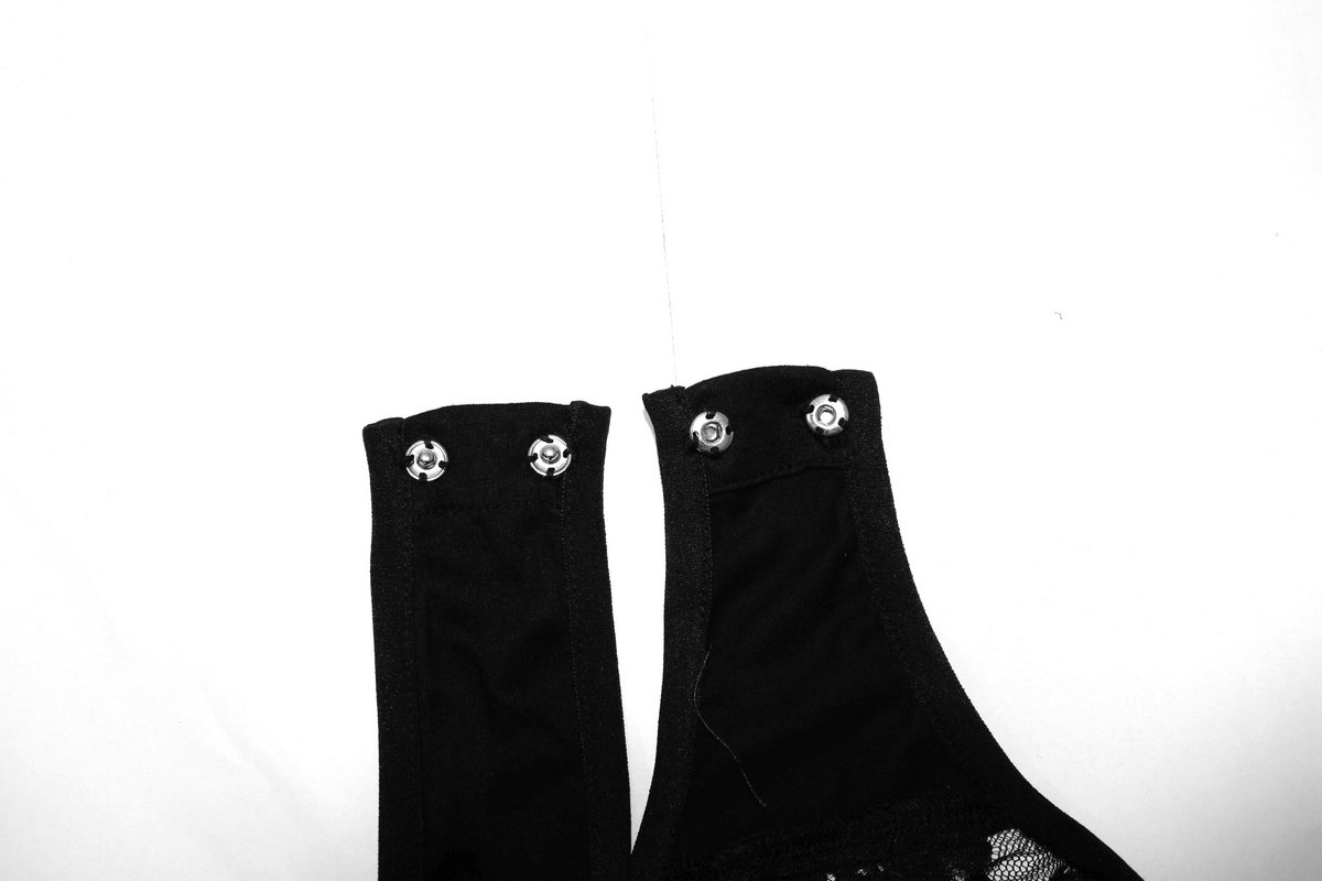 Close-up of straps on a sexy gothic lace bodysuit featuring snap buttons and black fabric details.