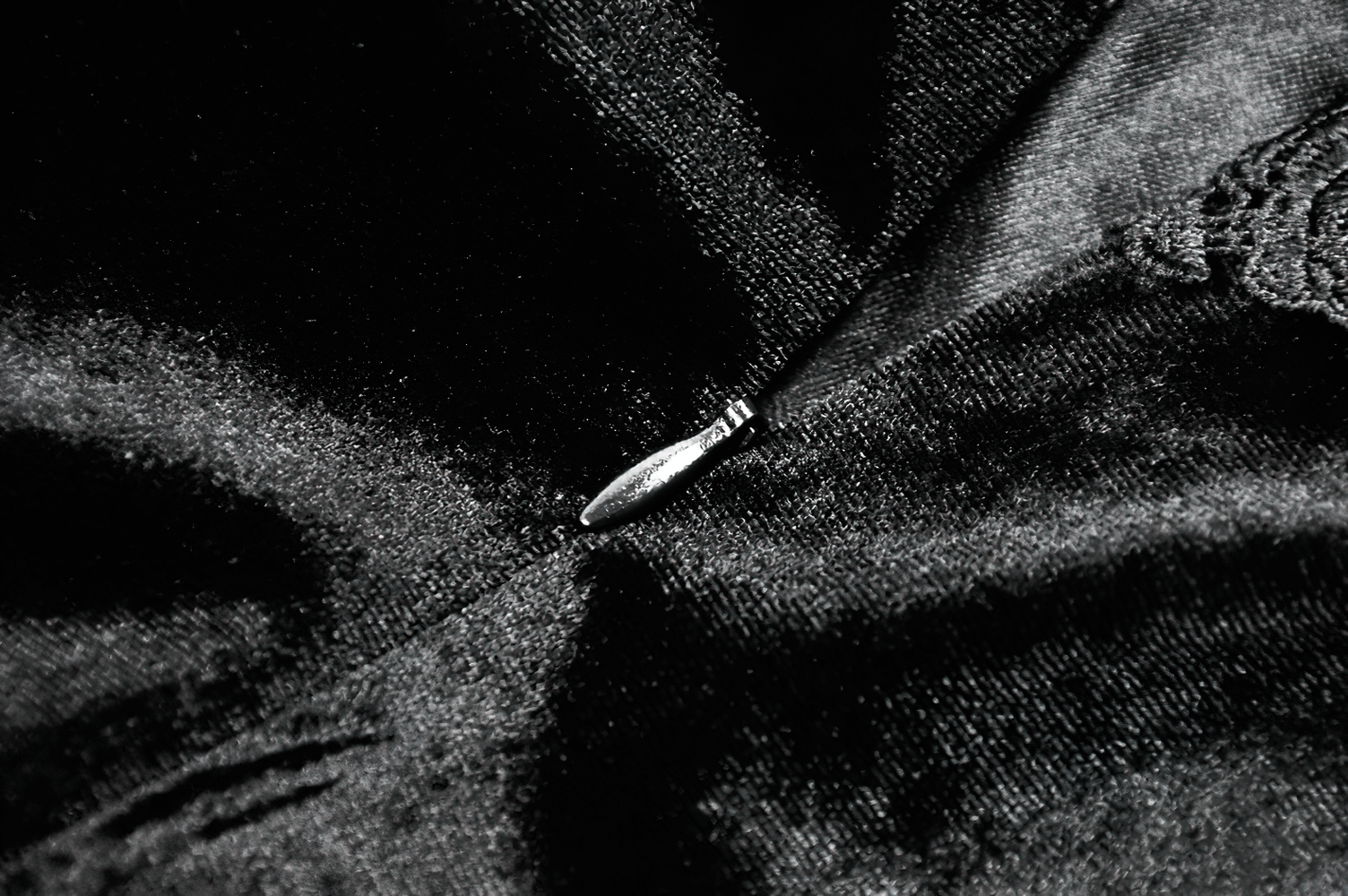 Close-up of black velvet fabric with intricate lace trim on a Gothic mini dress, highlighting elegance and detail.