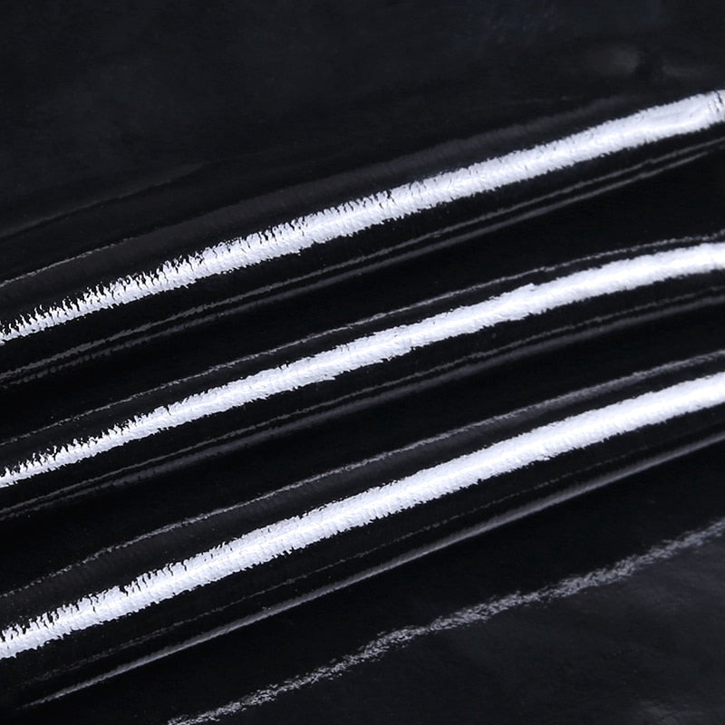 Close-up of black PU leather fabric with white stripes, perfect for gothic tank tops and stylish outfits.