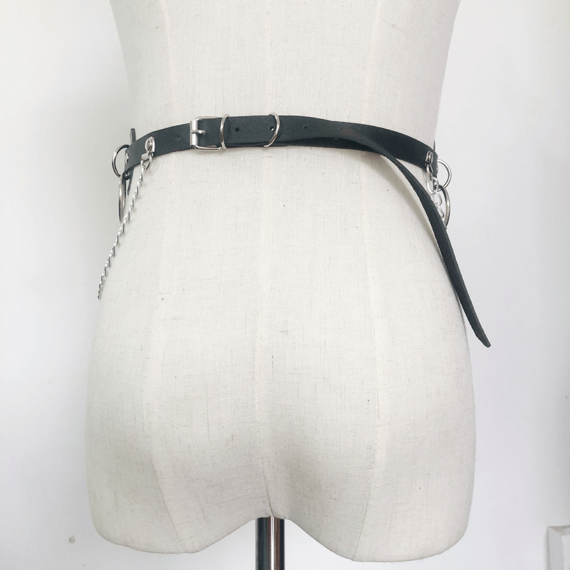 Edgy women's belt with rings and chains on mannequin, alternative fashion accessory for a bold statement outfit.