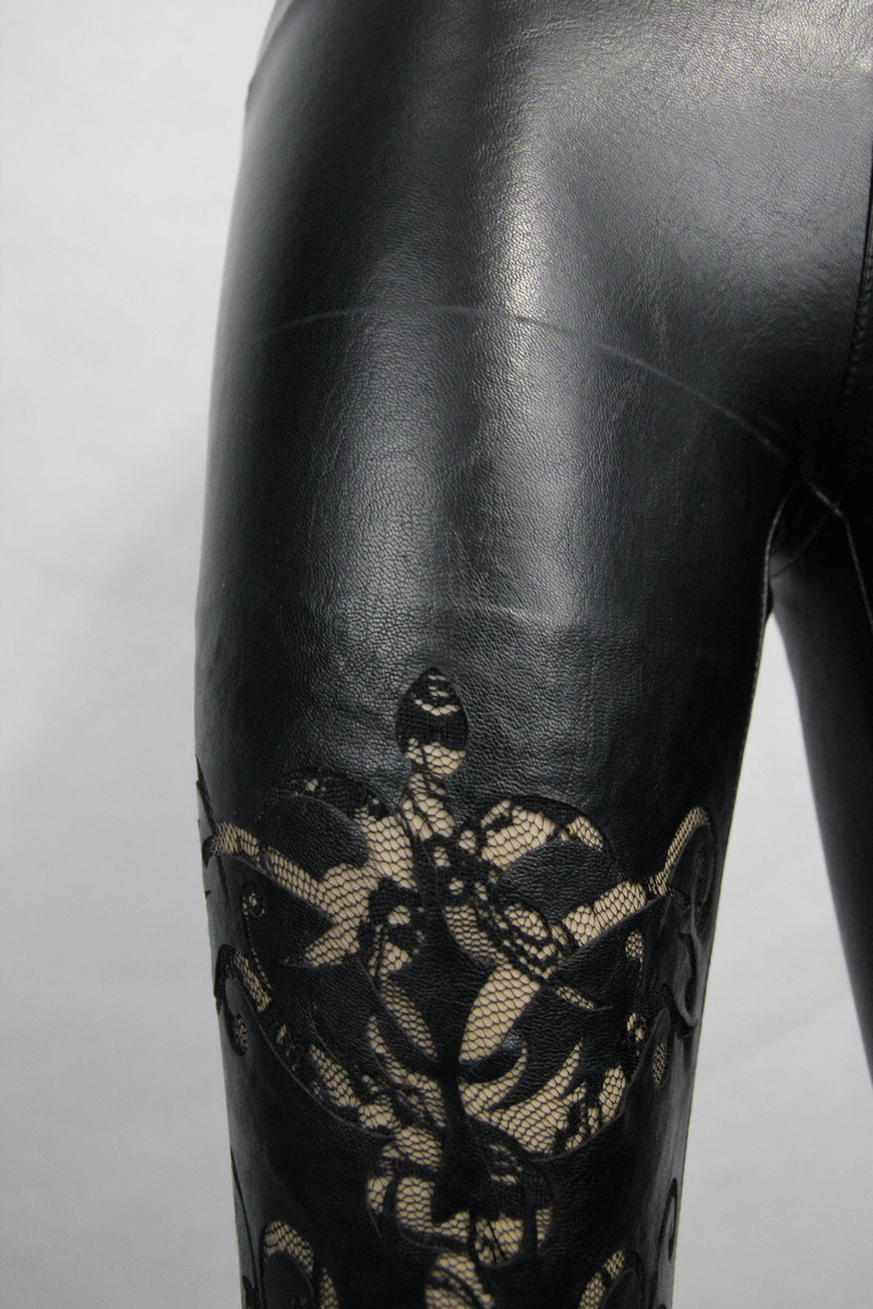 Close-up of black faux leather pants with elegant lace detailing, perfect for a gothic and trendy look.