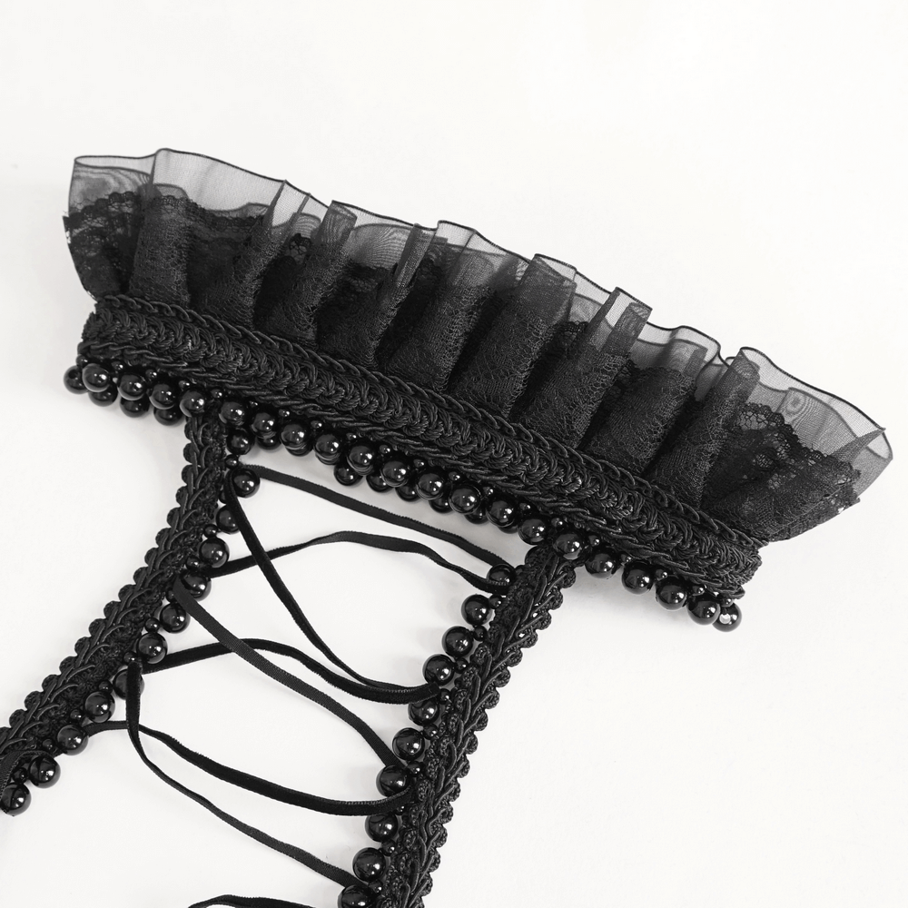 Close-up of black lace backless lingerie with ruffled trim and decorative pearls for a seductive look.
