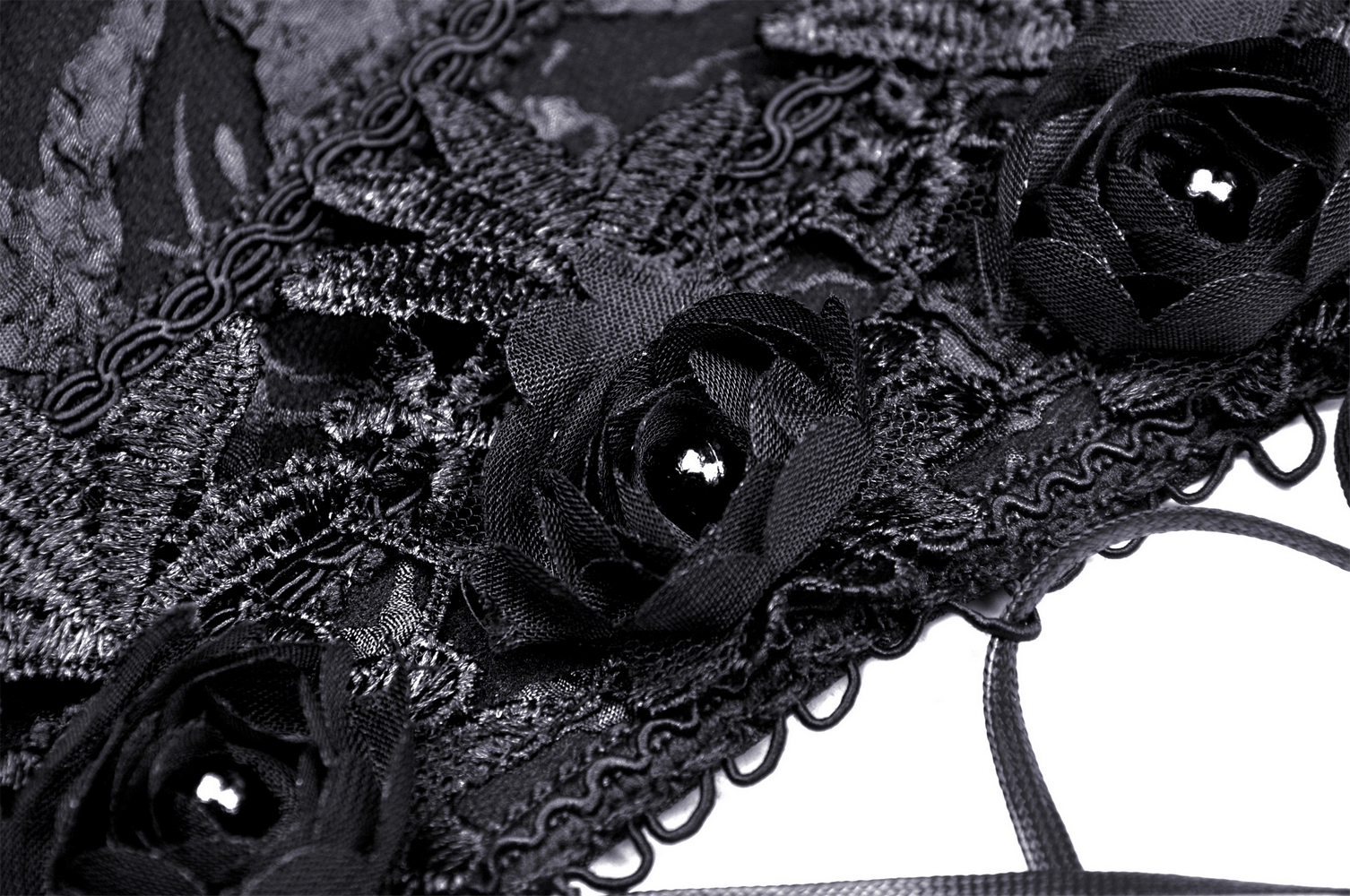 Close-up of a black lace corset with detailed floral embellishments and lace trim, adding a gothic touch.