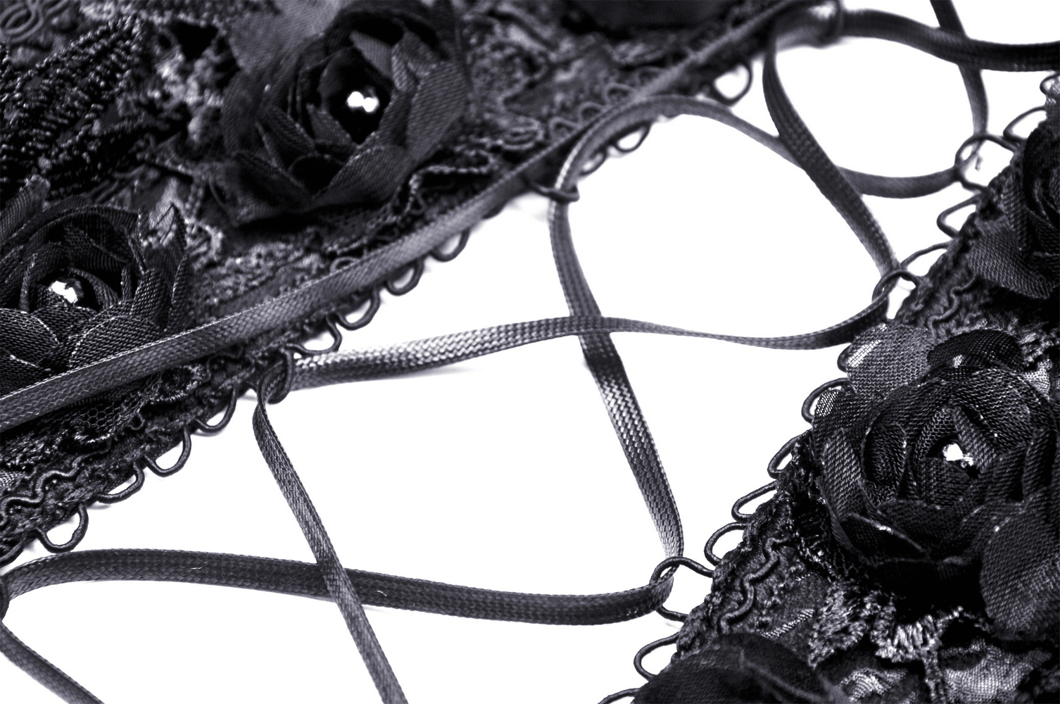 Black lace-up corset detail featuring elegant floral accents and intricate strap design.