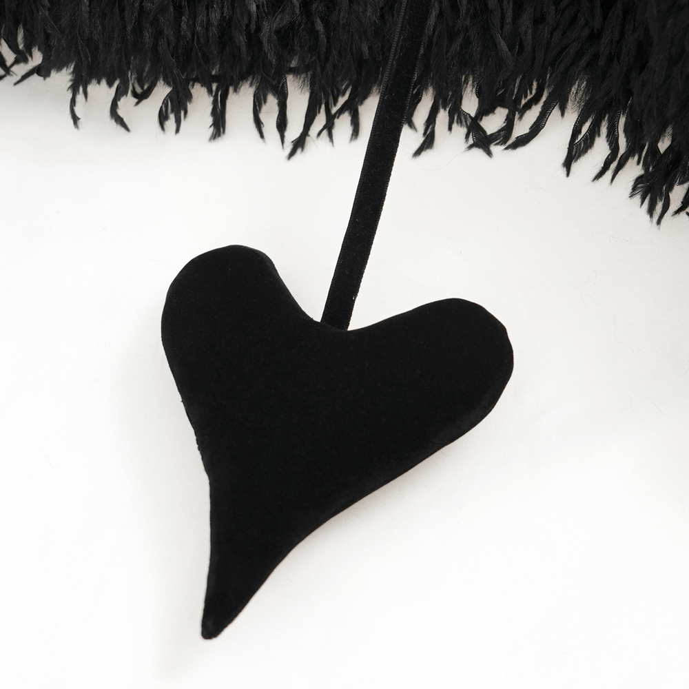 Black velvet heart accent hanging from a shaggy black faux fur cape, adding a gothic touch.