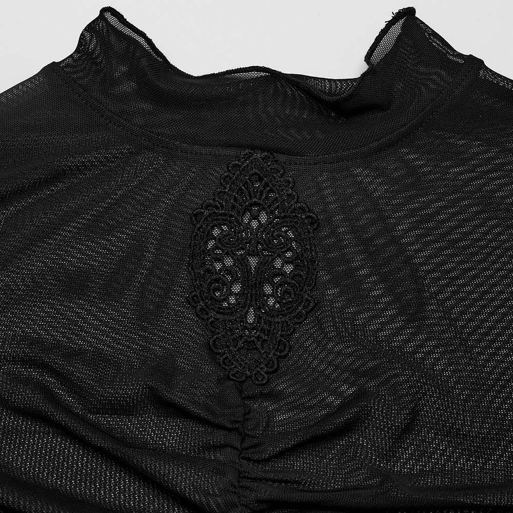 Close-up of sheer black mesh top featuring intricate skeleton embroidery and pleated details.