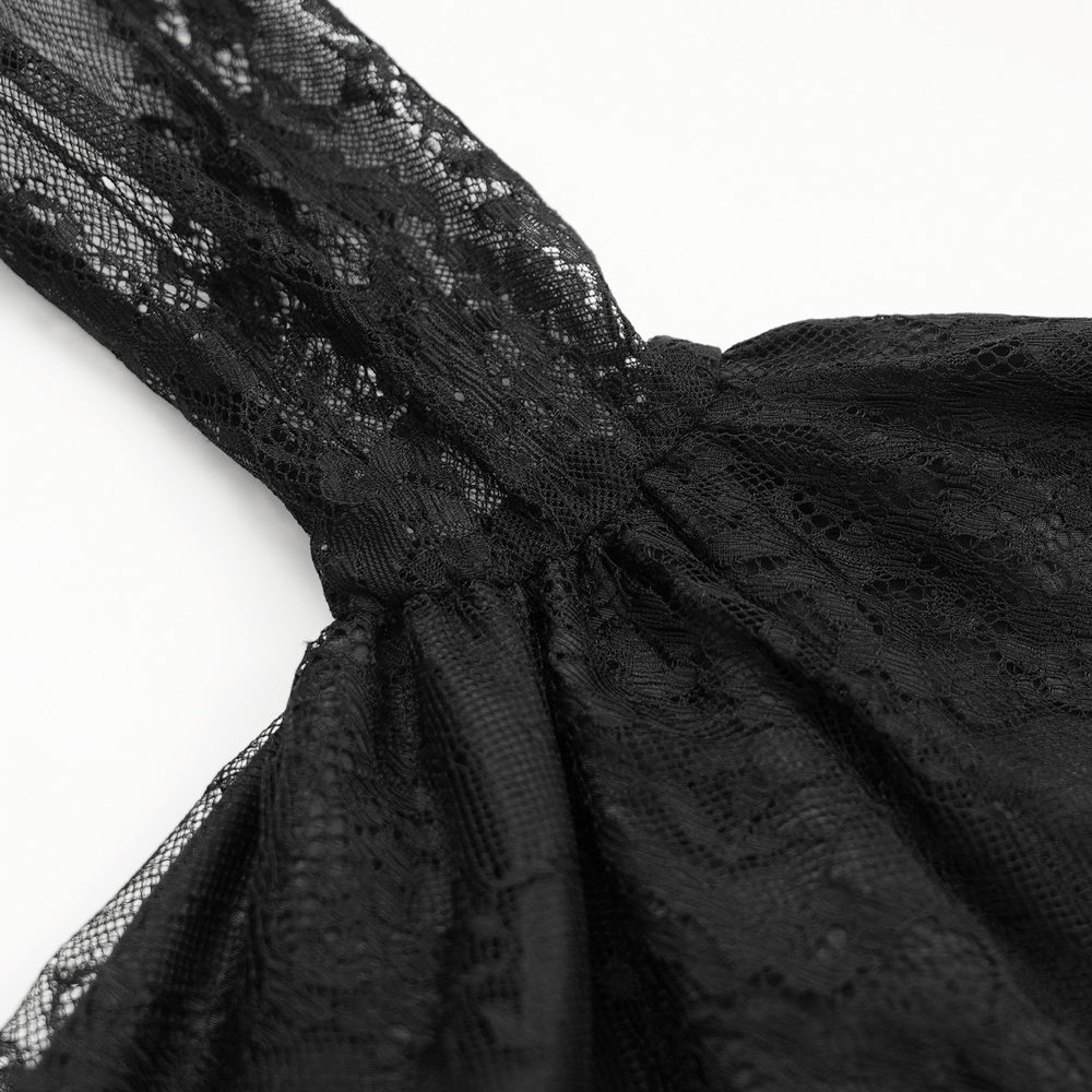 Close-up of the sheer lace fabric and flared sleeve of an elegant black high-low dress with intricate appliques.