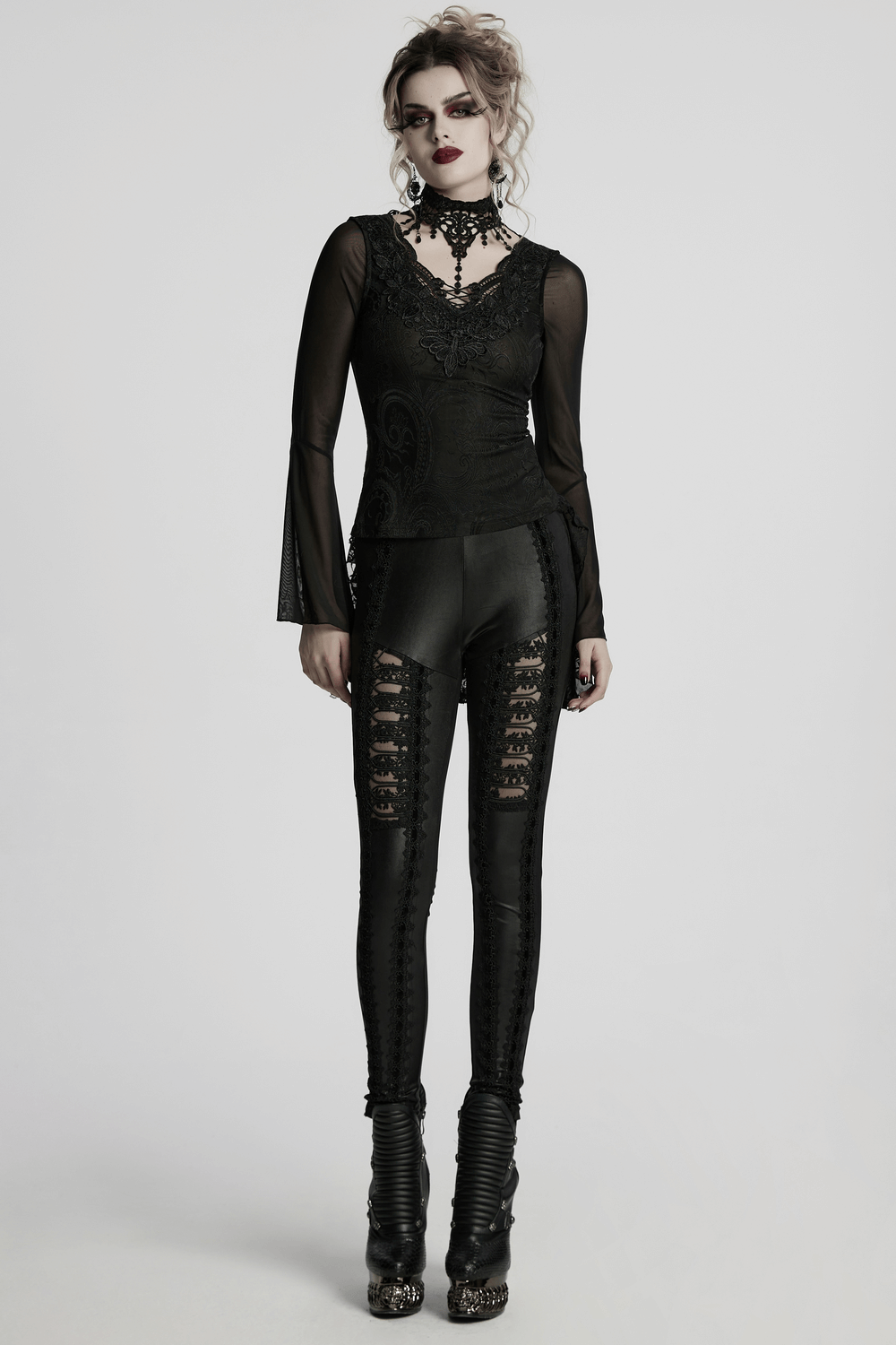 Gothic model wearing sheer lace top with bell sleeves and choker, paired with edgy black leggings, embodying Victorian elegance.