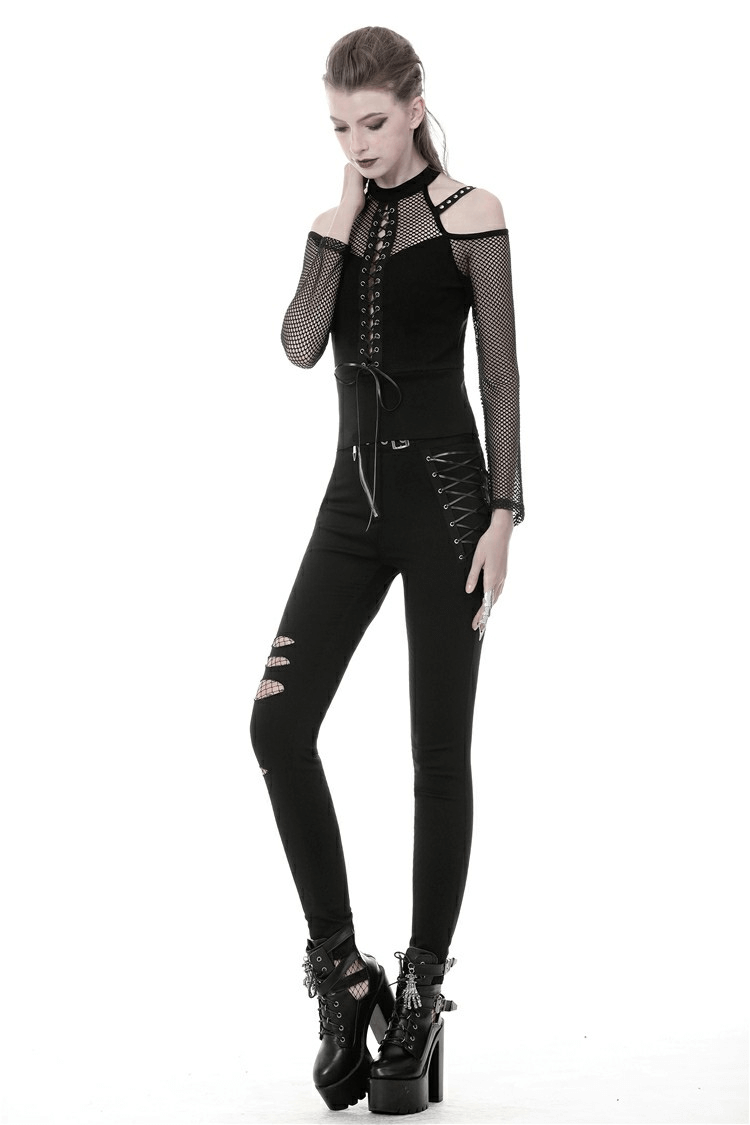 Model wearing a black sheer mesh long-sleeved top with lace-up front and fitted black jeans, showcasing an edgy style.