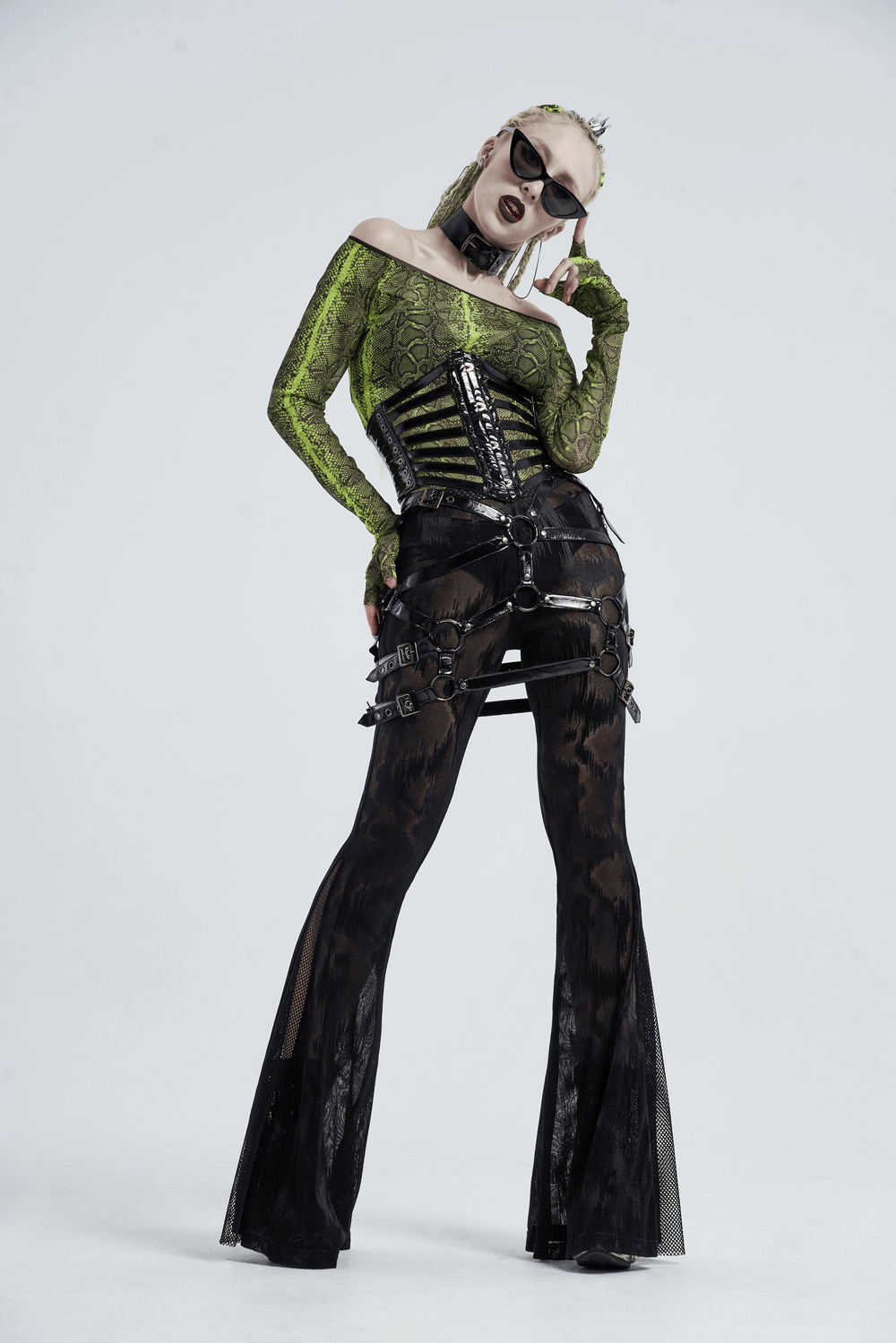 Model showcasing a shiny green and black punk corset belt, paired with edgy thigh-high pants and sunglasses.