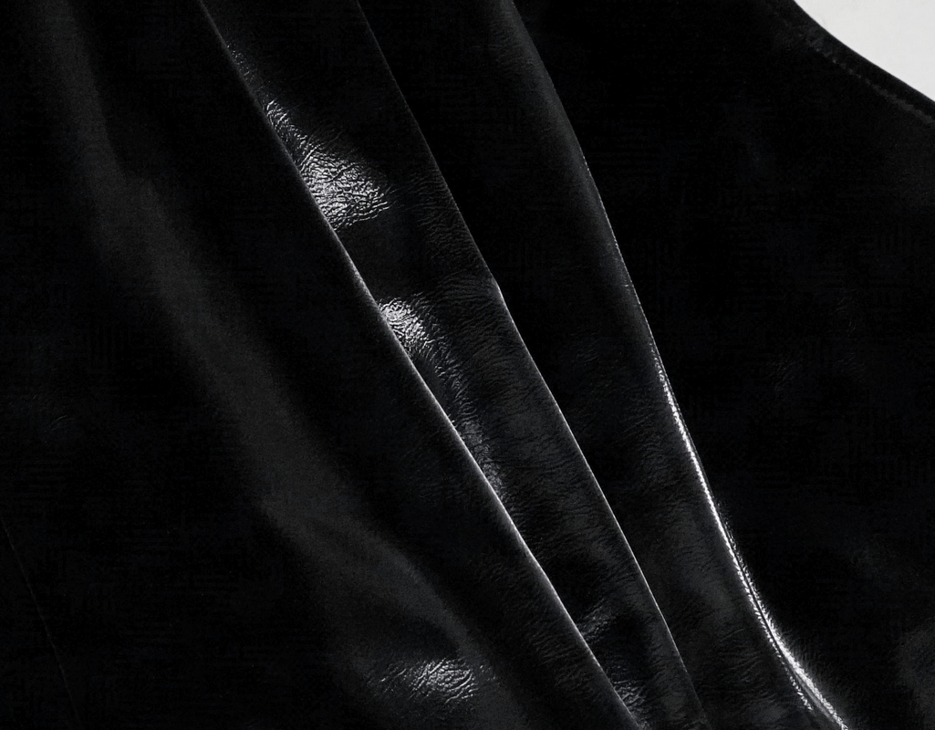 Close-up of shiny black PU leather fabric showcasing glossy texture for gothic women's jackets.