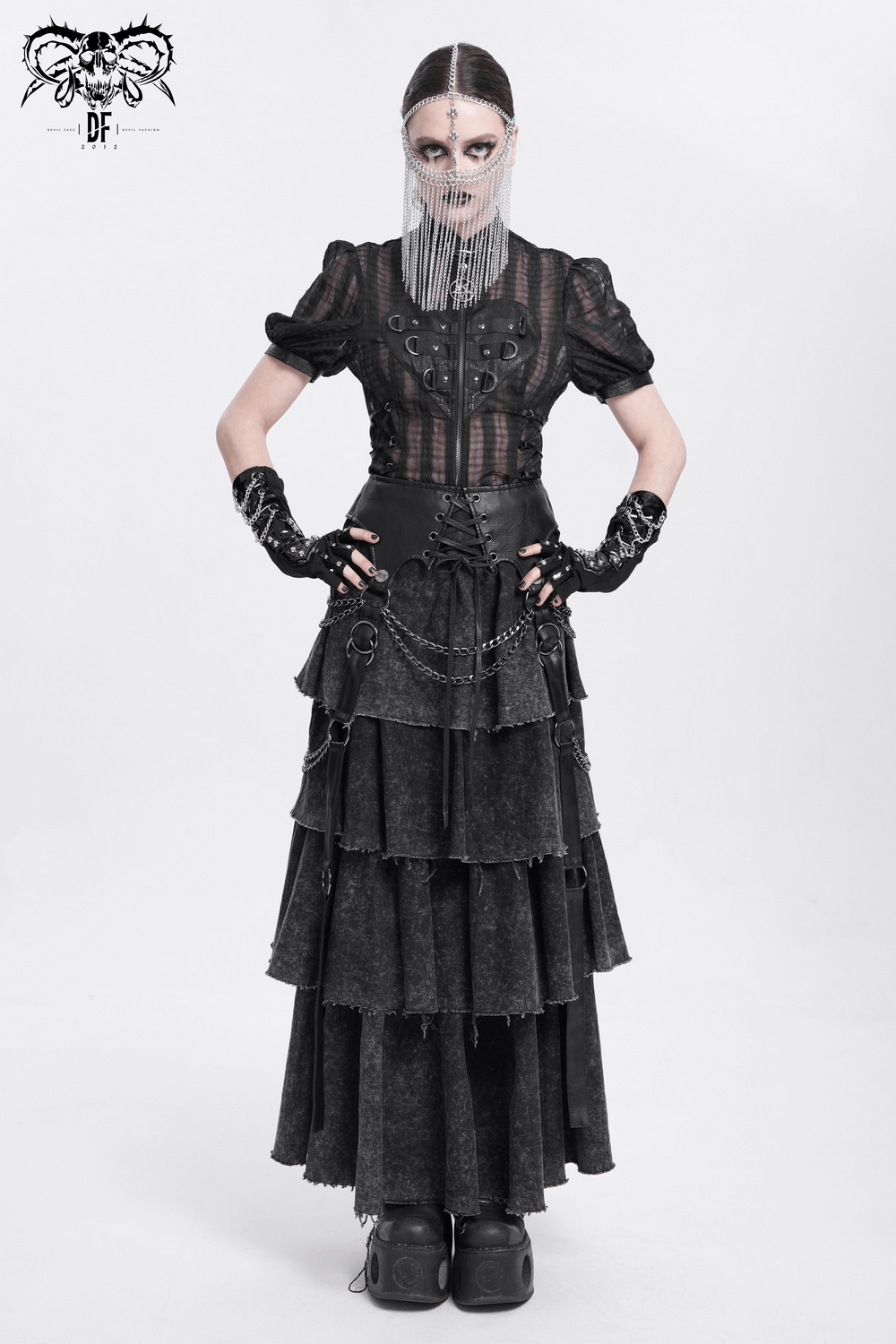 Model showcasing a punk black layered dress with chain accents and a unique face veil in a gothic style.