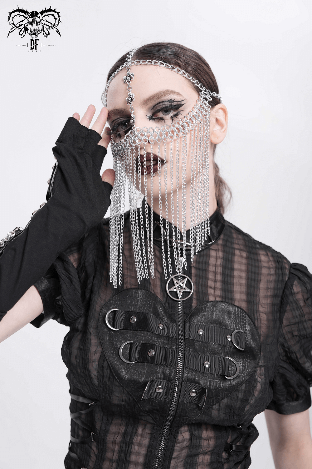 Model wearing a silver chain headpiece with fringe veil and gothic accents, showcasing punk fashion elegance.