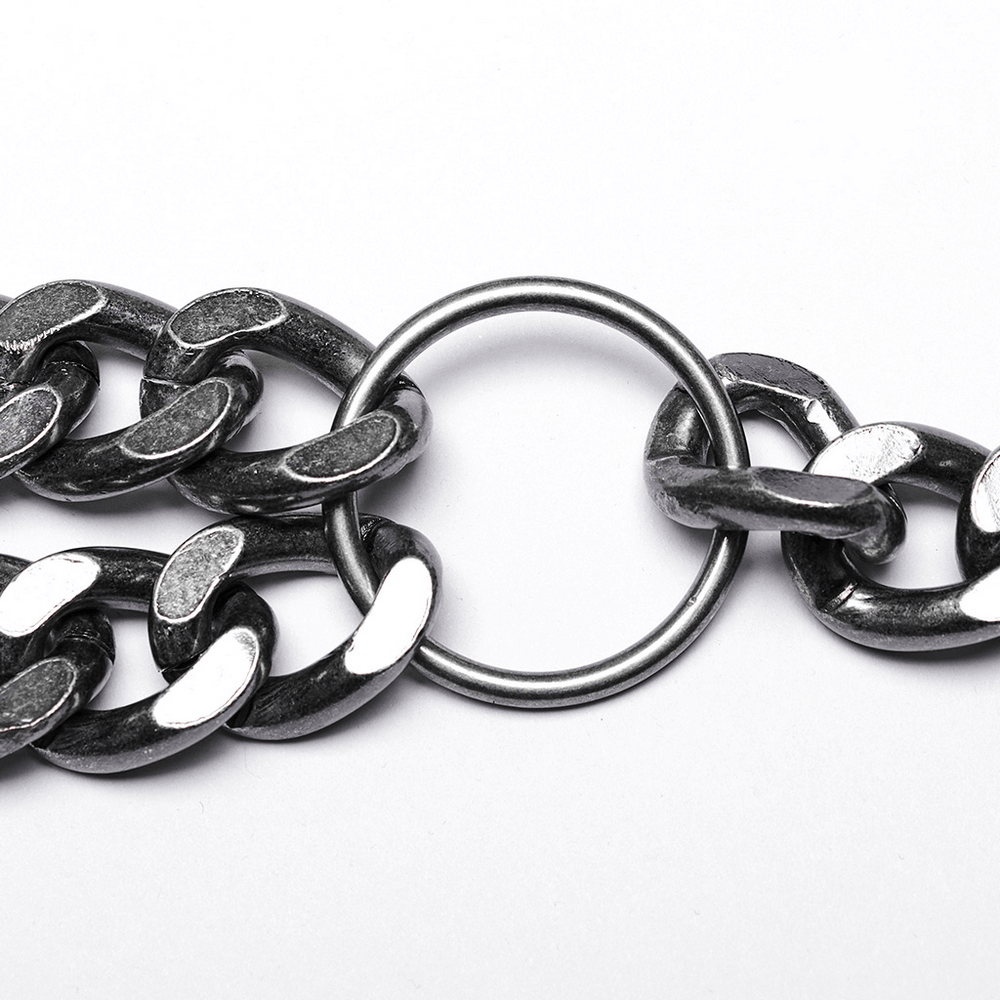 Close-up of silver-linked punk chain with oversized links and metal ring for a bold harness look.