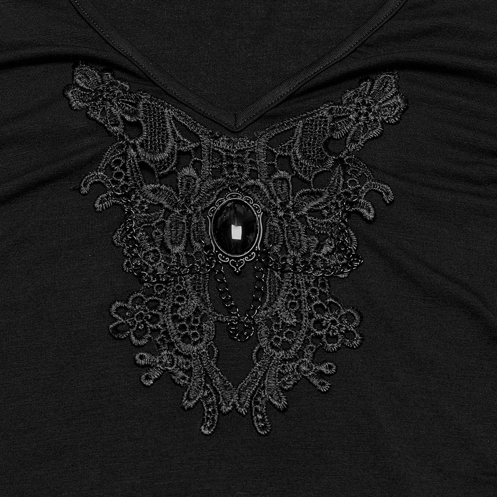Close-up of the skull and lace design on a black V-neck women's t-shirt, embellished with a black gemstone.