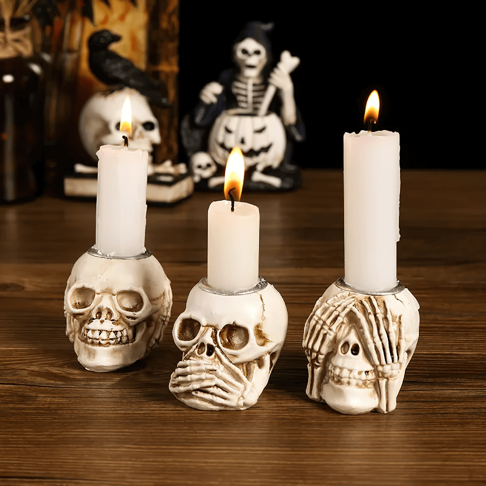 Spooky skull candle holders with skeleton hands, perfect for gothic and Halloween decor.