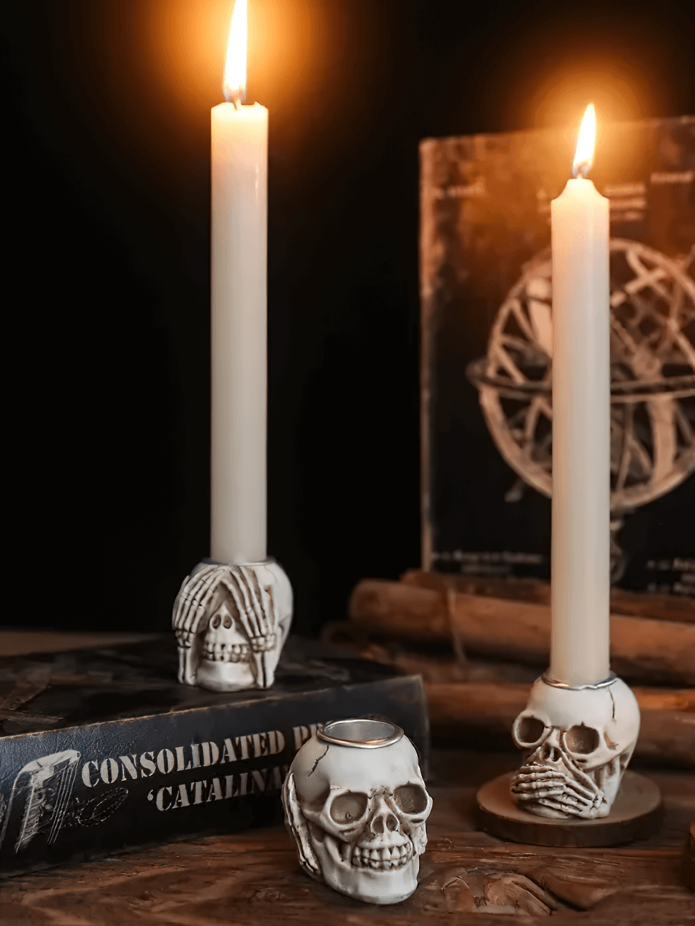 Skull candle holders with skeleton hand designs, perfect for Halloween and gothic decor.