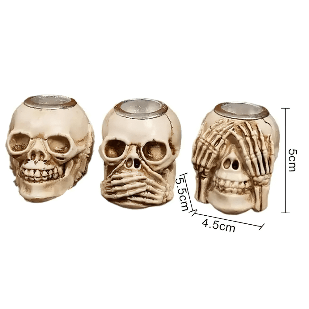 Set of three skull candle holders with skeleton hand designs, perfect for gothic or Halloween decor.